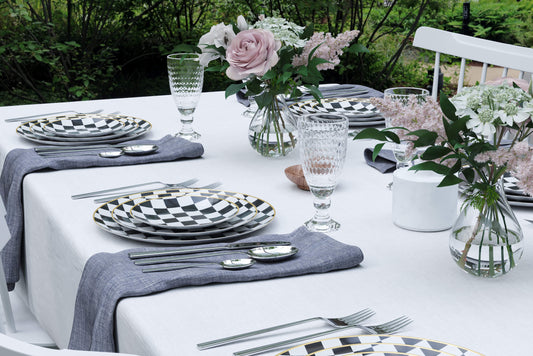 Casual outdoor picnic table set with black and white checkered plastic plates