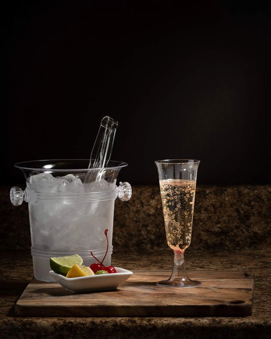 plastic champgne flute with an ice bucket against a black background